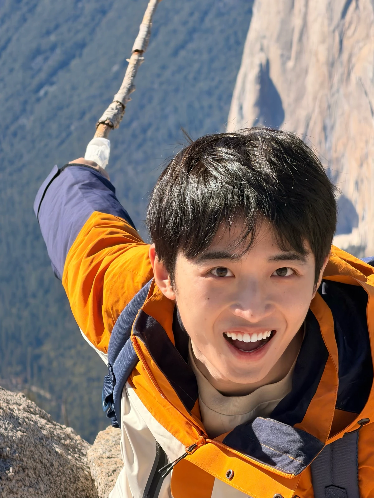 Chaoran outdoors with a mountain landscape behind him
